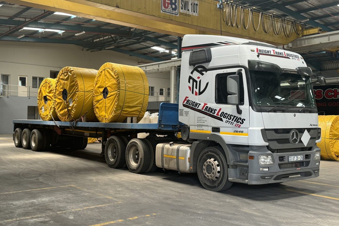 Freight Trans Logistics Actros 2646 with a loaded flatbed trailer of industrial reels